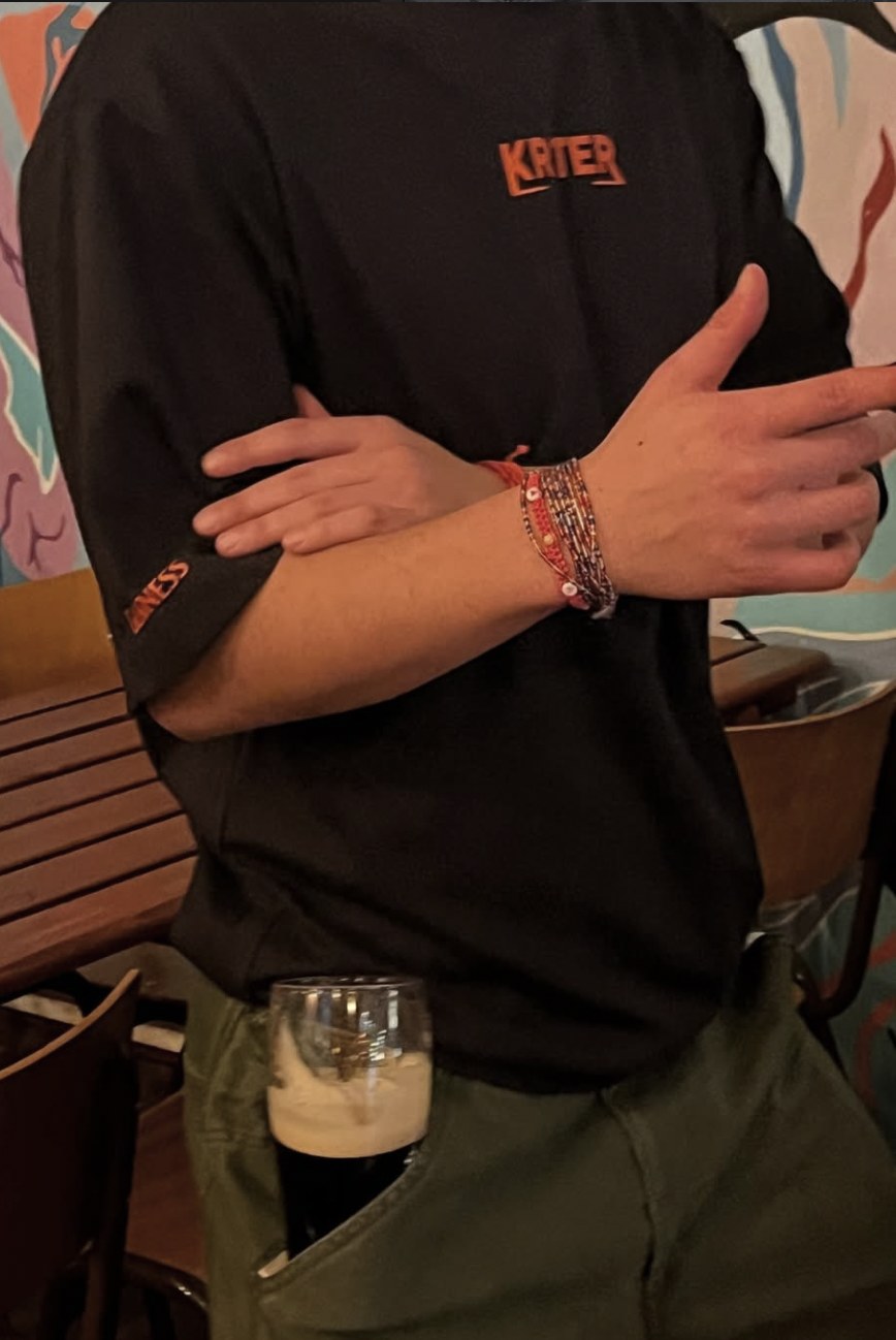 Staff member in a Krater shirt holding a Guinness